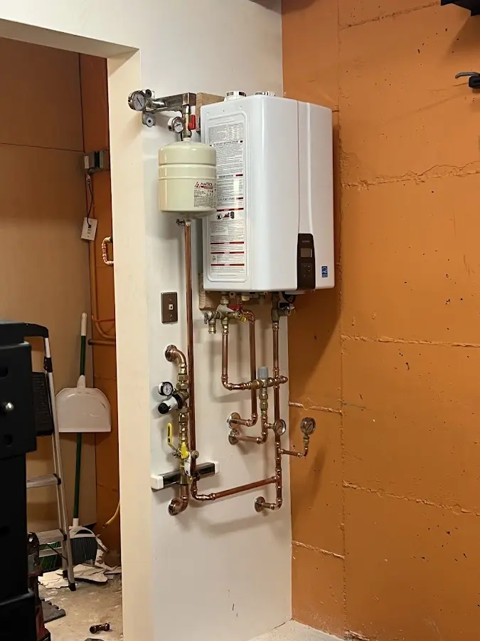 Plumbing technician inspecting water heater connections in Meadow Lake